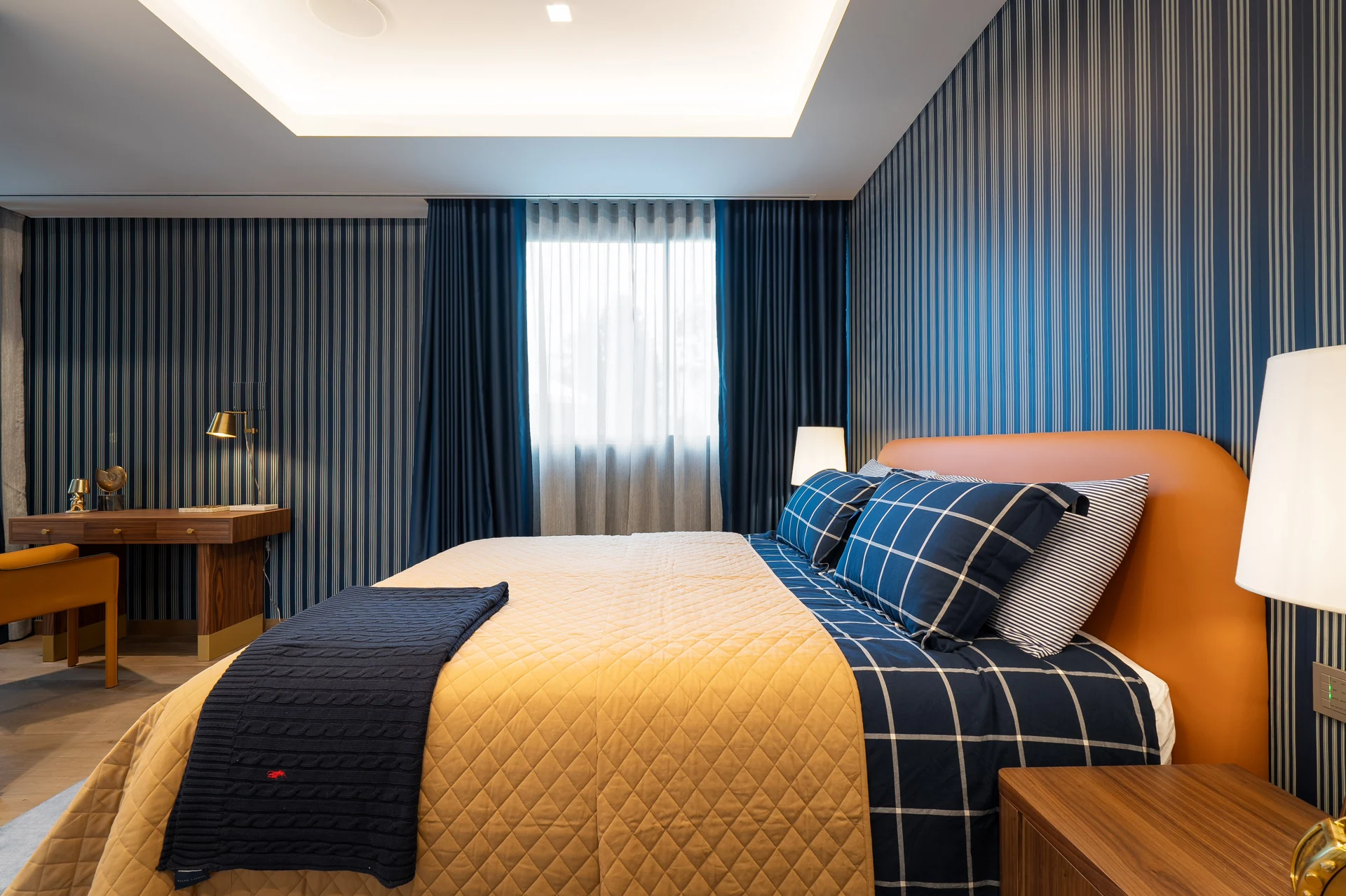 Bedroom with an orange headboard and blue wall panelling