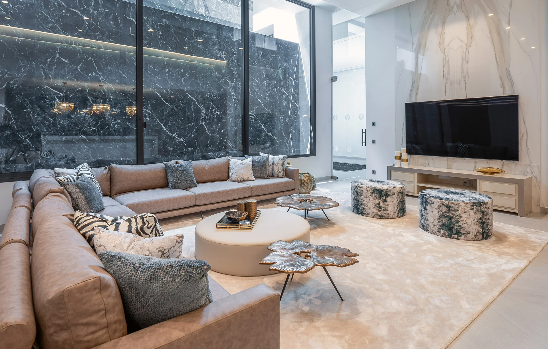 Lower-level lounge with a curved sofa and stone feature wall