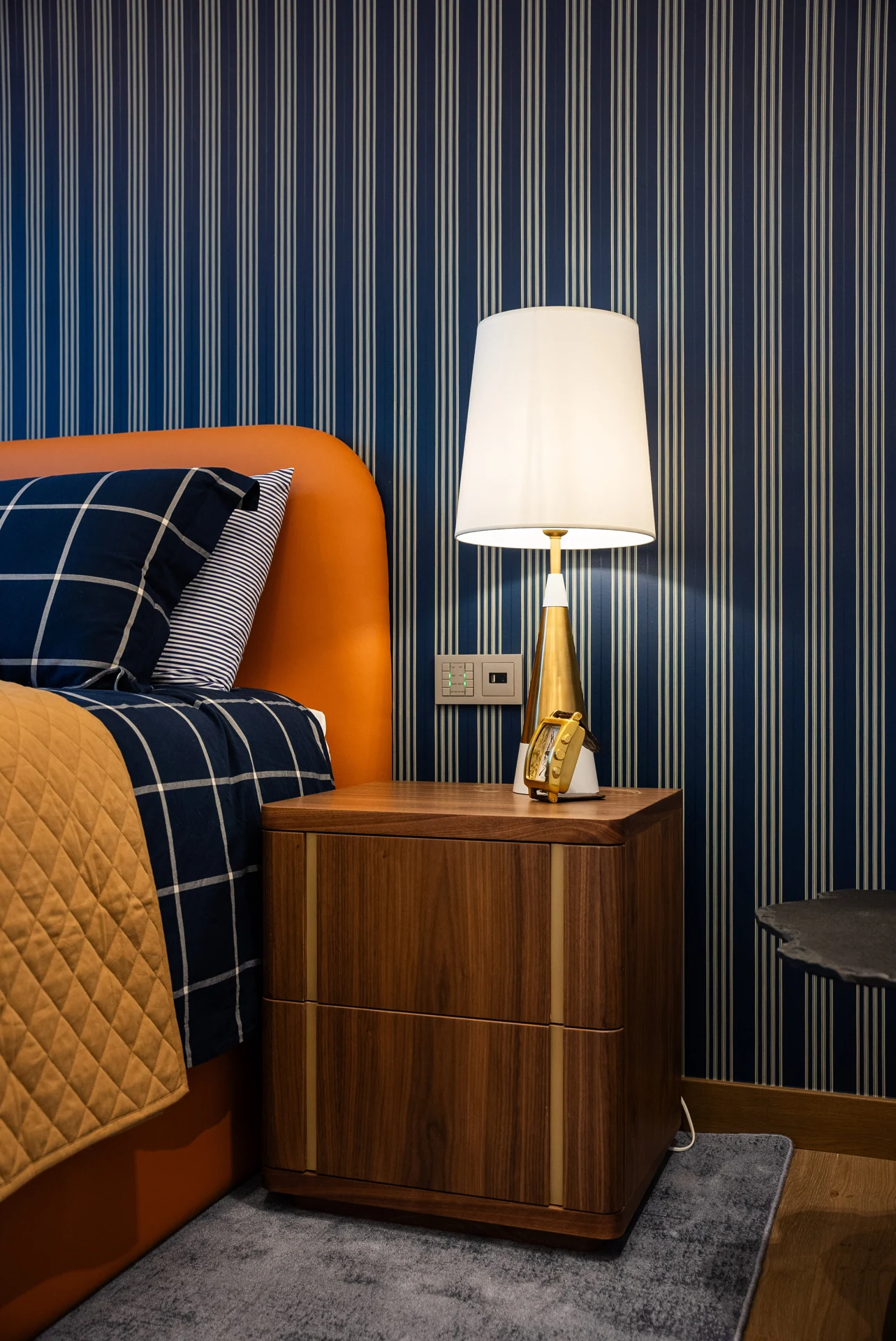 Blue-panelled bedroom with a bedside lamp