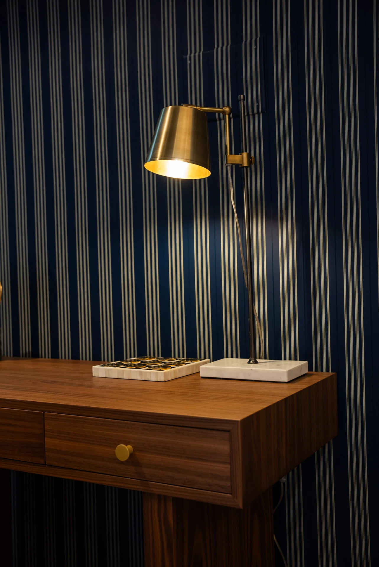 Timber writing desk against blue wall panelling