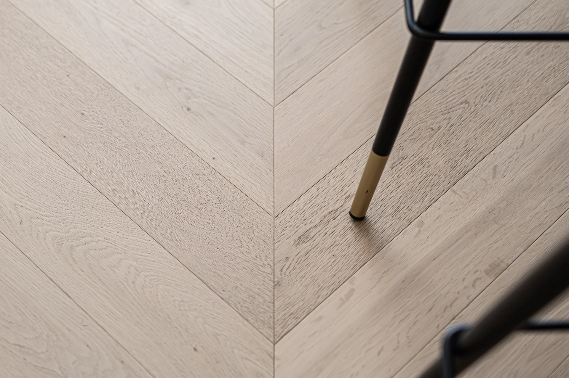 Herringbone timber flooring beside a kitchen stool