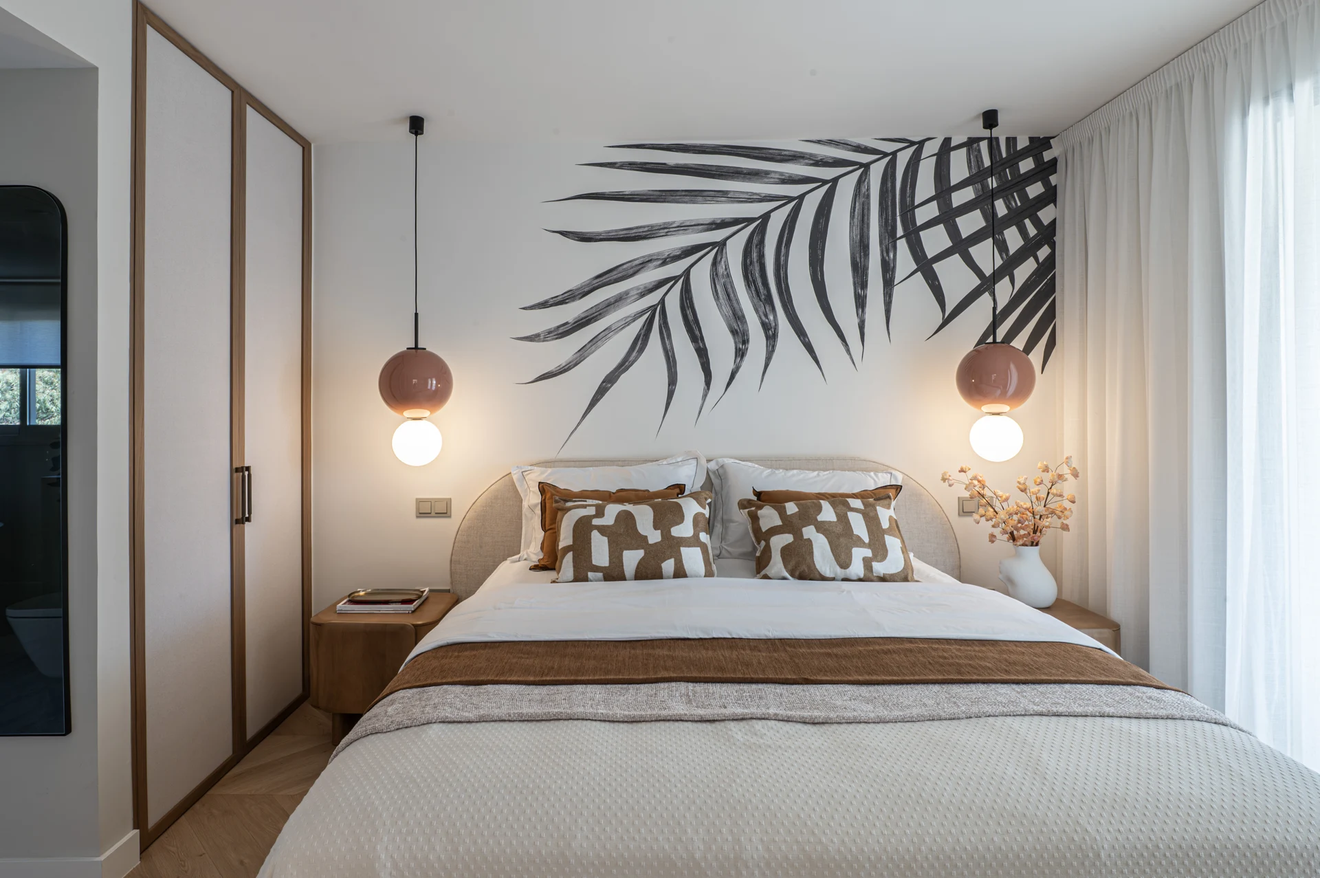 Bedroom with leaf-pattern wallcovering and hanging bedside lights