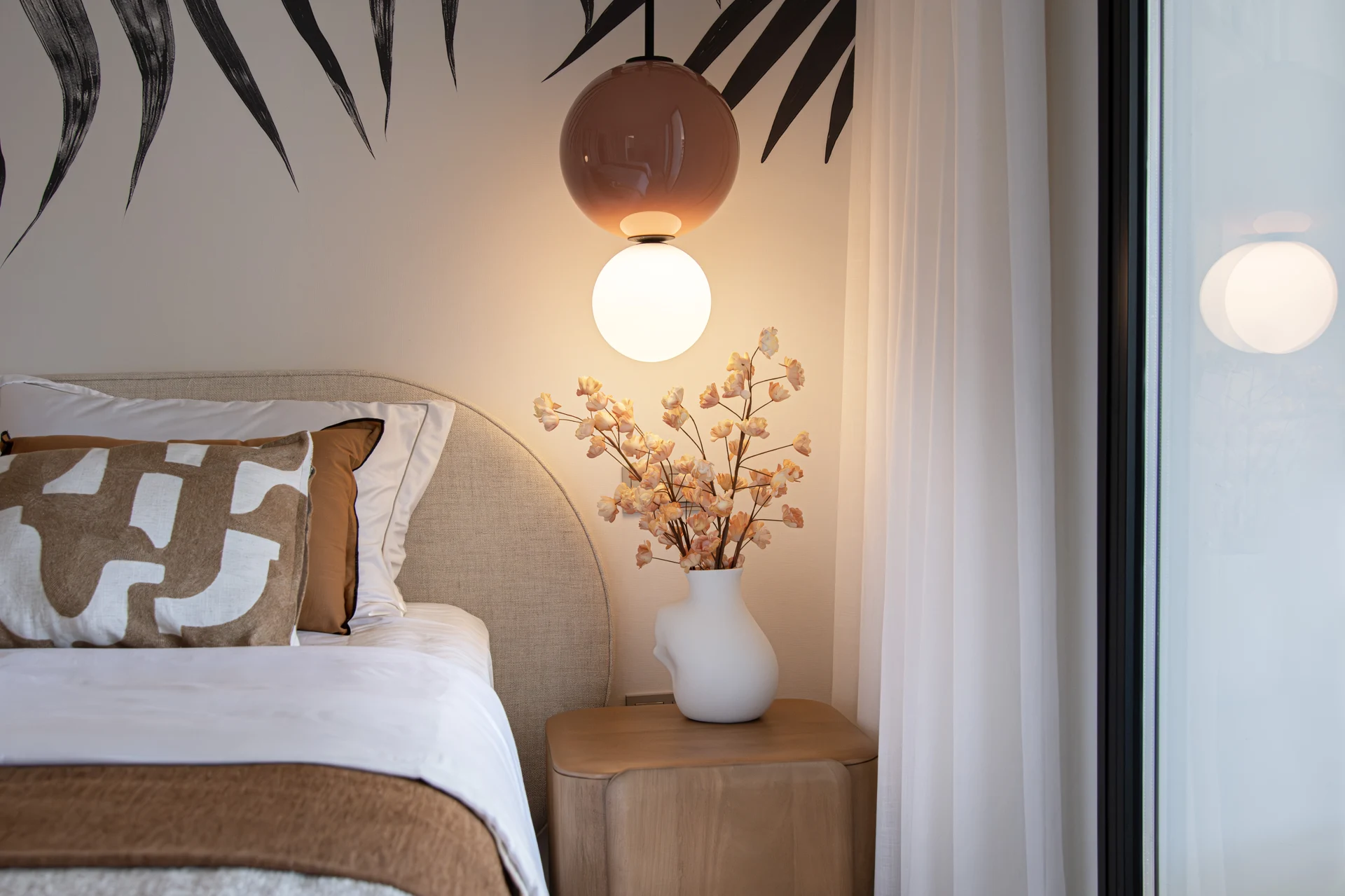 Bedroom styling with patterned cushions and pendant light