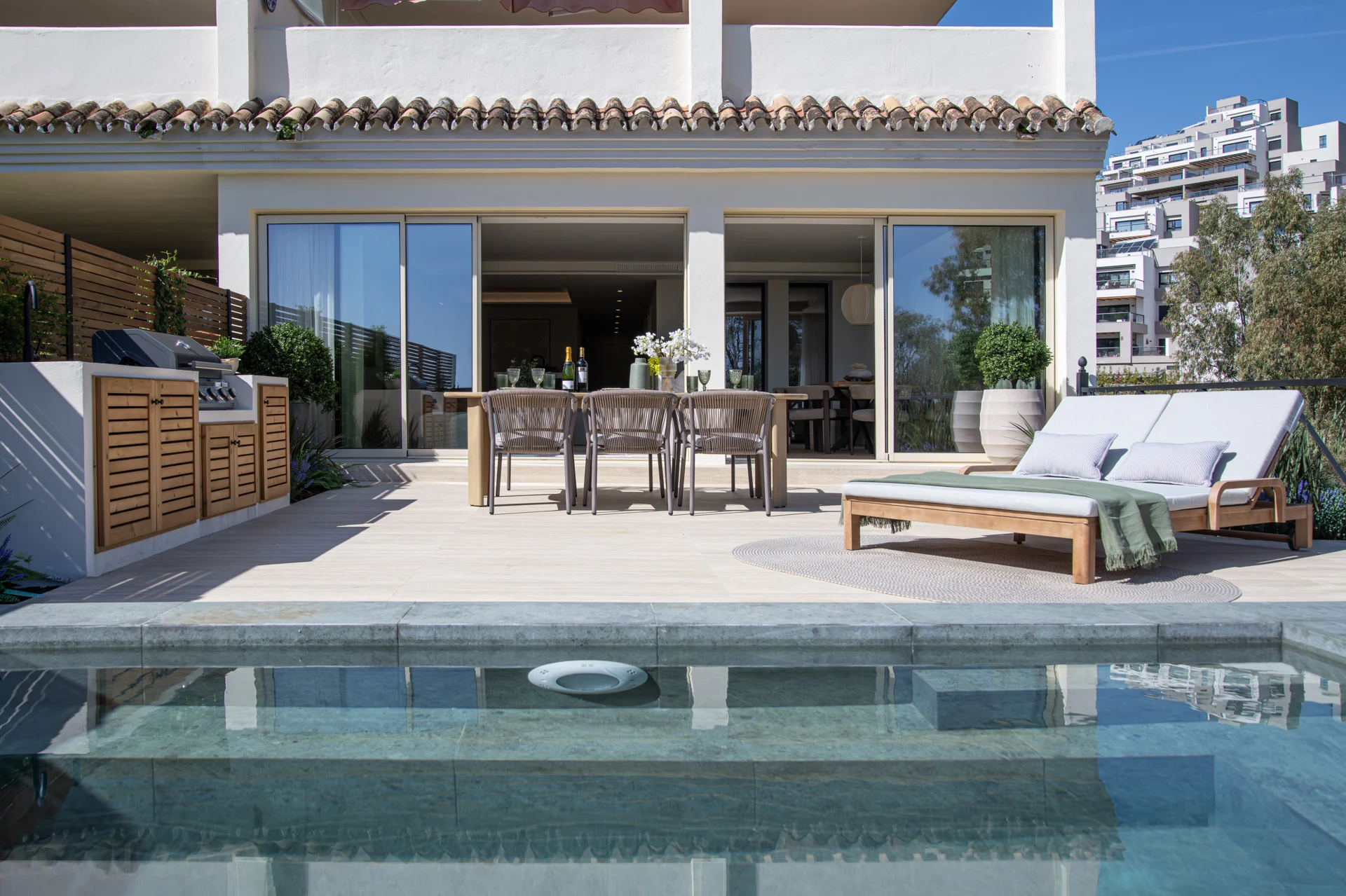 Apartment terrace with pool, dining table and sun loungers