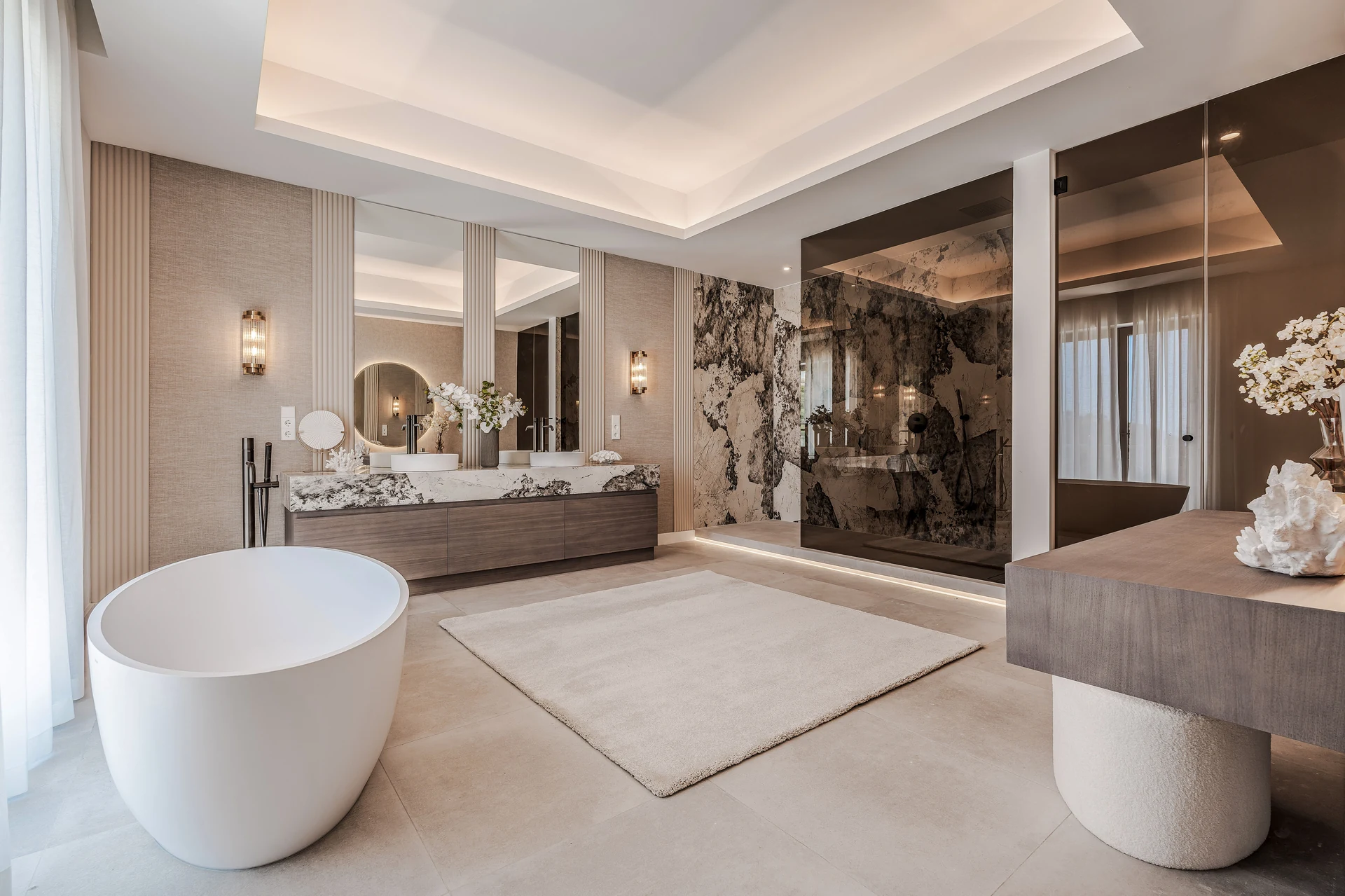 Finished bathroom with a freestanding bath, dramatic stone, timber cabinetry and warm lighting