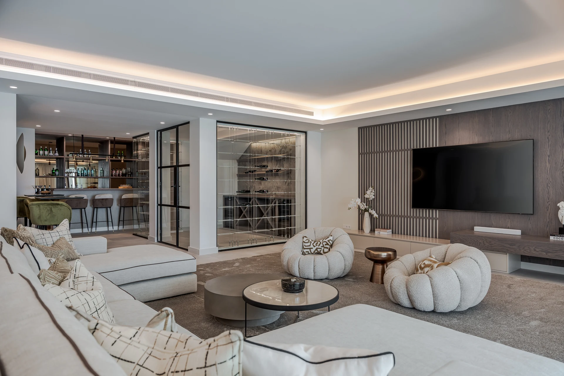 Finished entertainment lounge with a timber television wall, wine display, bar and upholstered seating